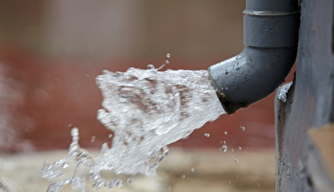 Rainwater being redirected by gutters to prevent foundation erosion in Charleston home